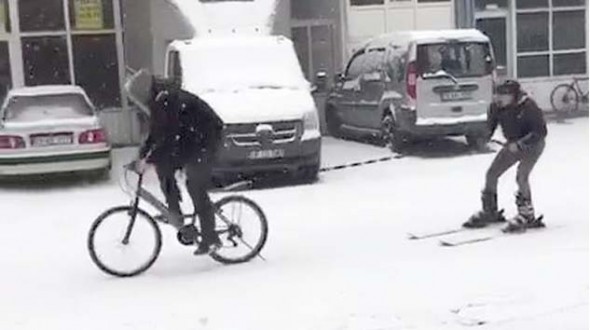 Karla kaplanan yolda kayak takımları ile kayak yaptı